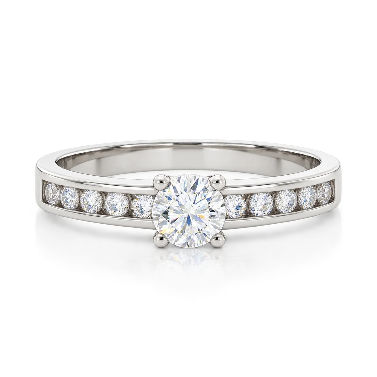 Anillo de oro blanco con circonita redonda central en cuatro garras y circonitas laterales engastadas en carril
