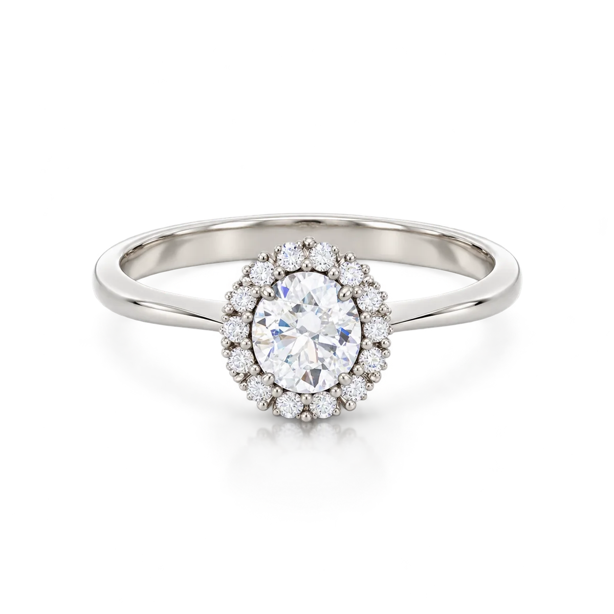 Anillo de oro blanco con circonita oval central rodeada por una orla de circonitas redondas y aro liso