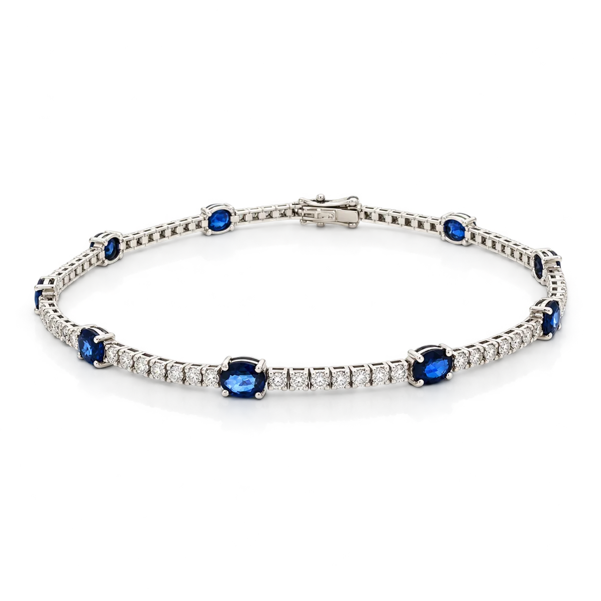 Pulsera de oro blanco con zafiros azules ovalados alternados con hileras de diamantes talla brillante